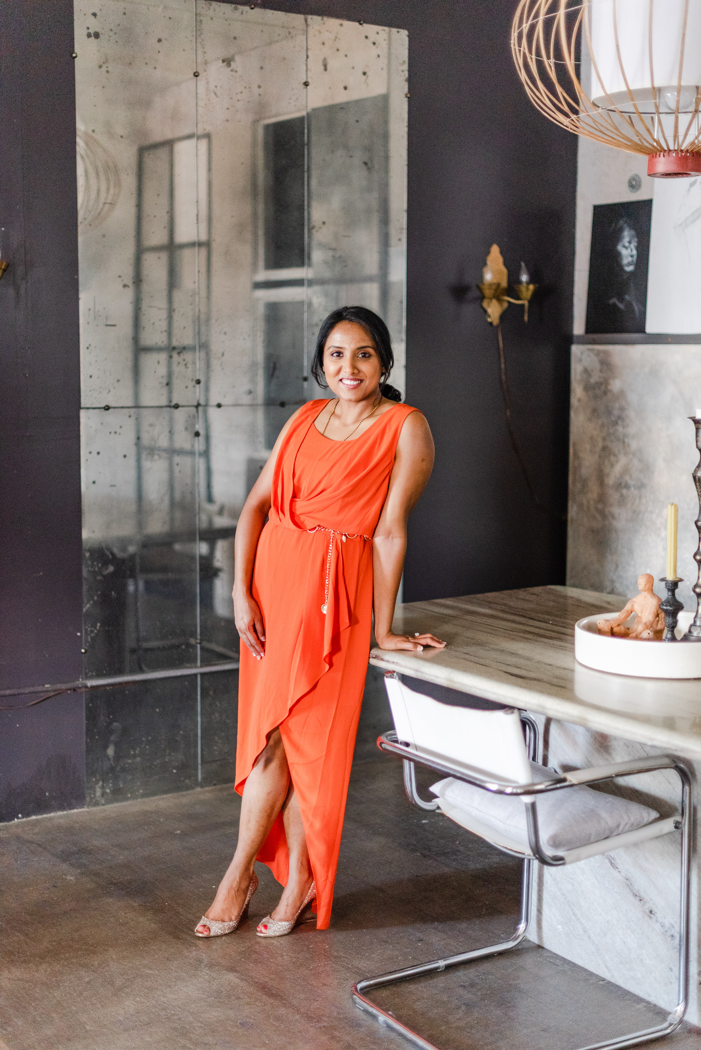 Divya in an orange dress in an editorial setting